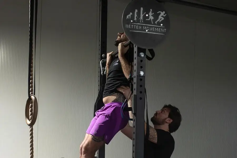 Coach guidant une adhérente lors d’un exercice de traction assistée