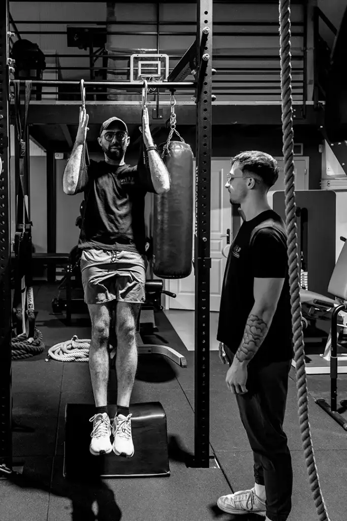 Loris accompagne un adhérent pendant un exercice de traction